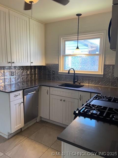 5003 S Boston Ave, Tulsa, OK 74105 - kitchen featuring dishwasher, dark countertops, light tile patterned floors, white cabinetry, and backsplash
