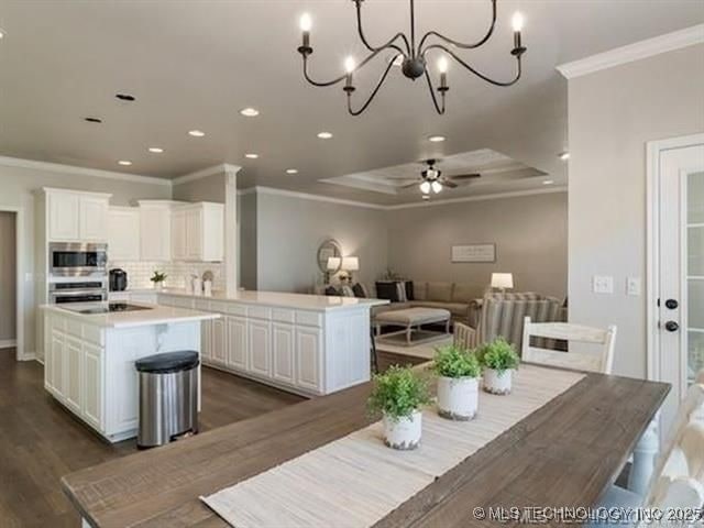 408 W Fairway Ct, Broken Arrow, OK 74011 - dining space with ornamental molding, a raised ceiling, a chandelier, recessed lighting, and dark wood-style flooring