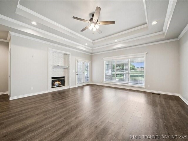 408 W Fairway Ct, Broken Arrow, OK 74011 - unfurnished living room with a tray ceiling, dark wood-style floors, ceiling fan, a fireplace, and crown molding