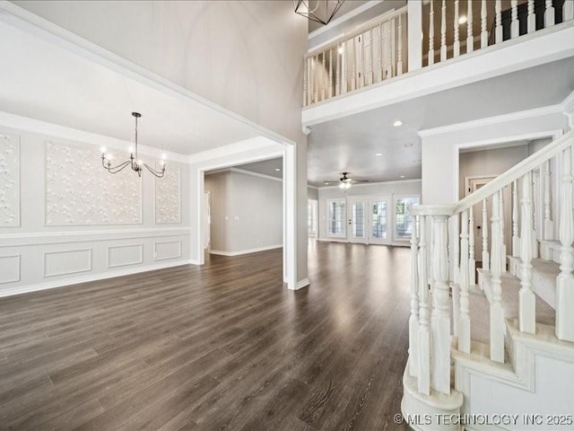 408 W Fairway Ct, Broken Arrow, OK 74011 - unfurnished living room with ornamental molding, a towering ceiling, a chandelier, dark wood-style floors, and stairs