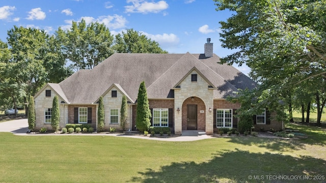 27920 160th St, Coweta, OK 74429 - french country home with stone siding, a chimney, a front lawn, and brick siding