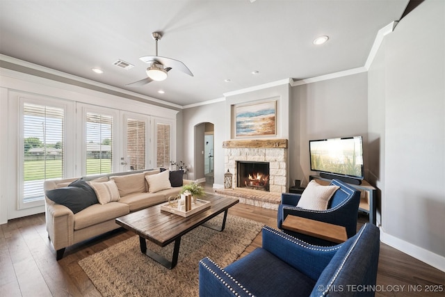 27920 160th St, Coweta, OK 74429 - living room with crown molding, arched walkways, wood finished floors, a ceiling fan, and a stone fireplace