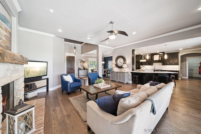 27920 160th St, Coweta, OK 74429 - living area featuring crown molding, a stone fireplace, a ceiling fan, recessed lighting, and wood-type flooring