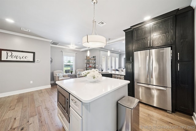 27920 160th St, Coweta, OK 74429 - kitchen with stainless steel appliances, crown molding, light countertops, a kitchen island, and light wood-type flooring