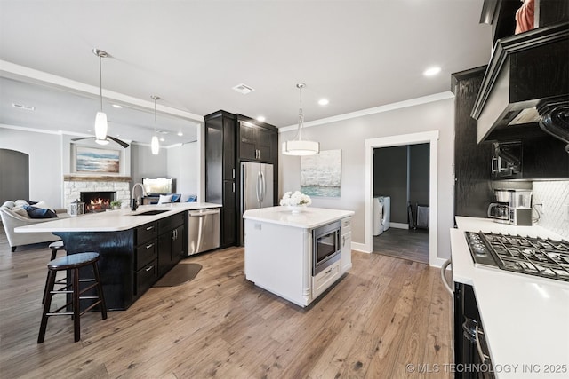 27920 160th St, Coweta, OK 74429 - kitchen with appliances with stainless steel finishes, light countertops, crown molding, a stone fireplace, and dark cabinets