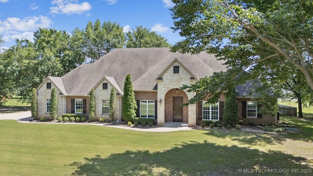 27920 160th St, Coweta, OK 74429 - view of front facade featuring stone siding, a front yard, and a shingled roof