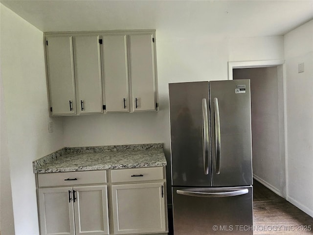 306 G St SE, Ardmore, OK 73401 - kitchen featuring freestanding refrigerator, dark wood-style flooring, and light stone countertops