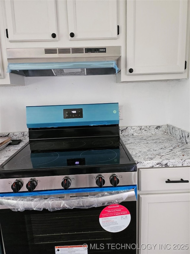 306 G St SE, Ardmore, OK 73401 - kitchen view of under cabinet range hood, stainless steel range with electric cooktop, and white cabinets