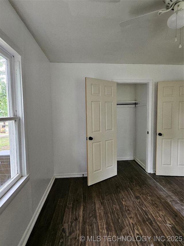 306 G St SE, Ardmore, OK 73401 - unfurnished bedroom featuring dark wood-type flooring, a ceiling fan, and a closet