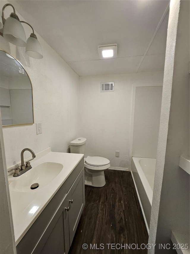 306 G St SE, Ardmore, OK 73401 - bathroom with wood finished floors, vanity, a tub to relax in, and a shower