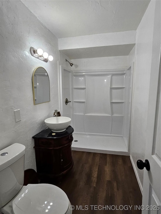 306 G St SE, Ardmore, OK 73401 - full bath with wood finished floors, a shower, vanity, and a textured wall