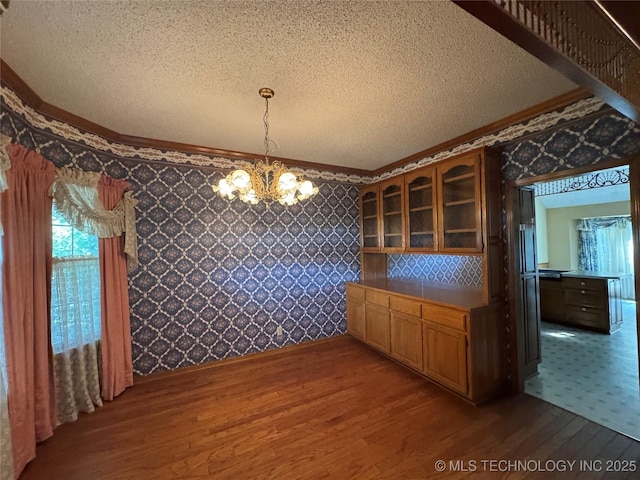 4525 Summit Pl, Sand Springs, OK 74063 - unfurnished dining area featuring wood finished floors, crown molding, a chandelier, a textured ceiling, and wallpapered walls