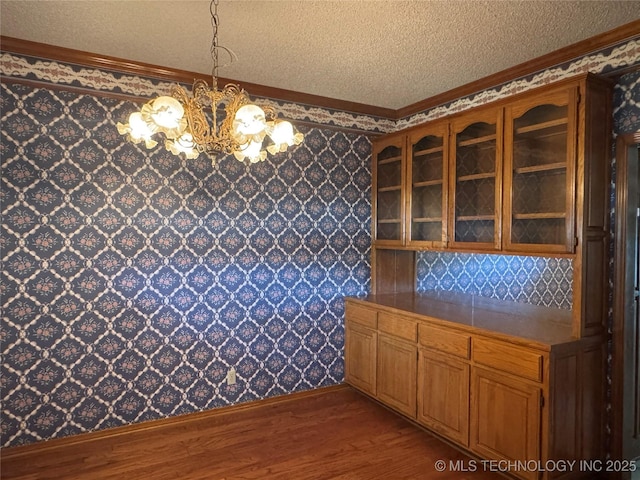 4525 Summit Pl, Sand Springs, OK 74063 - unfurnished dining area with a chandelier, wood finished floors, a textured ceiling, crown molding, and wallpapered walls