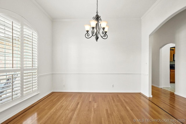 1005 E Fargo St, Broken Arrow, OK 74012 - spare room with arched walkways, plenty of natural light, wood finished floors, a chandelier, and ornamental molding