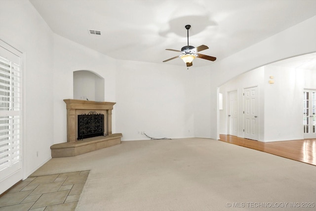 1005 E Fargo St, Broken Arrow, OK 74012 - unfurnished living room with ceiling fan, a fireplace, carpet flooring, and arched walkways