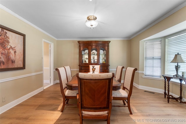 6016 E 52nd Pl, Tulsa, OK 74135 - dining space with light wood finished floors and crown molding