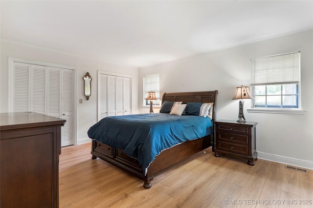6016 E 52nd Pl, Tulsa, OK 74135 - bedroom featuring multiple closets and light wood-style flooring