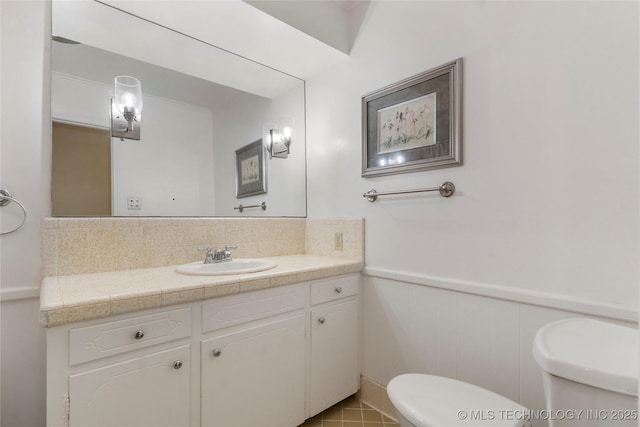 6016 E 52nd Pl, Tulsa, OK 74135 - bathroom with vanity, decorative backsplash, and wainscoting