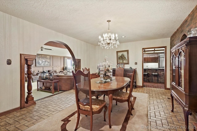 17331 S 174th Ave E, Bixby, OK 74008 - dining area featuring brick flooring, arched walkways, a textured ceiling, and a chandelier
