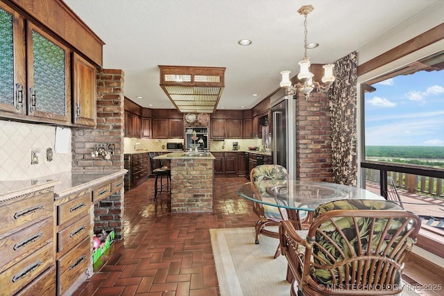 17331 S 174th Ave E, Bixby, OK 74008 - kitchen with backsplash, stainless steel microwave, a center island, recessed lighting, and a breakfast bar area