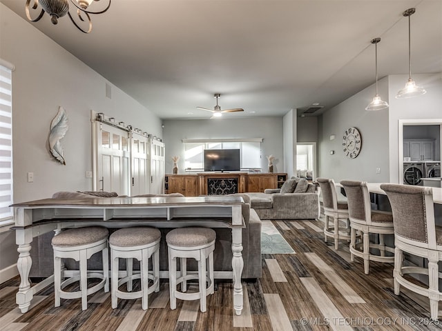 353800 E 5400th Rd, Maramec Twp, OK 74045 - kitchen featuring washer and clothes dryer, dark wood-style flooring, a breakfast bar, and a ceiling fan