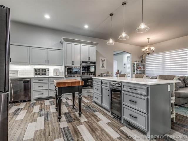 353800 E 5400th Rd, Maramec Twp, OK 74045 - kitchen featuring gray cabinetry, wine cooler, stainless steel appliances, arched walkways, and a chandelier