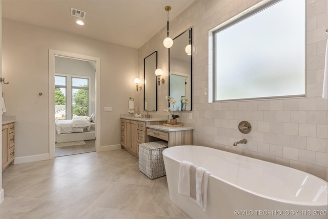 3528 S Troost Ave, Tulsa, OK 74105 - ensuite bathroom featuring vanity, a freestanding tub, tile patterned flooring, and recessed lighting