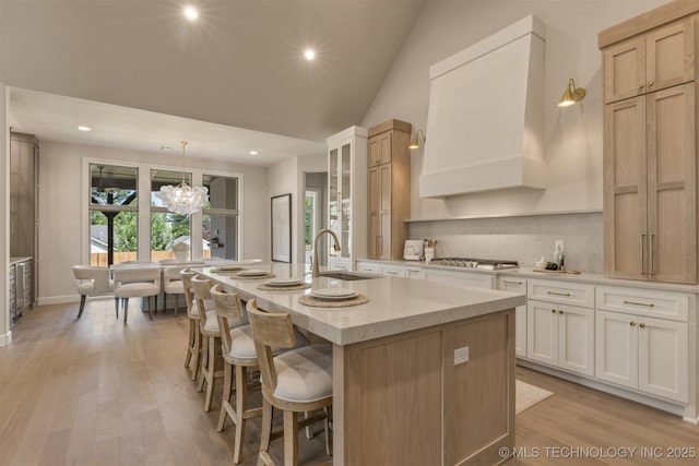 3528 S Troost Ave, Tulsa, OK 74105 - kitchen featuring custom range hood, a center island with sink, stainless steel gas stovetop, recessed lighting, and a kitchen bar