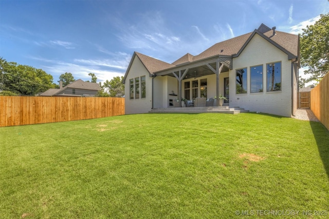 3528 S Troost Ave, Tulsa, OK 74105 - rear view of house featuring a fenced backyard, a ceiling fan, roof with shingles, and brick siding