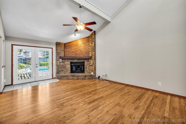 2847 W 115th Pl S, Jenks, OK 74037 - unfurnished living room featuring french doors, a ceiling fan, wood finished floors, lofted ceiling, and a stone fireplace