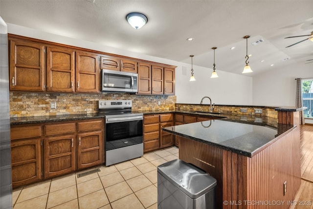 2847 W 115th Pl S, Jenks, OK 74037 - kitchen featuring appliances with stainless steel finishes, backsplash, a peninsula, lofted ceiling, and hanging light fixtures