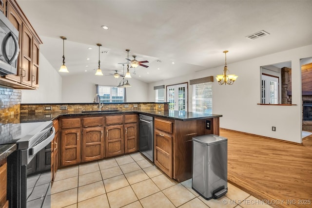 2847 W 115th Pl S, Jenks, OK 74037 - kitchen with appliances with stainless steel finishes, a ceiling fan, pendant lighting, a chandelier, and backsplash