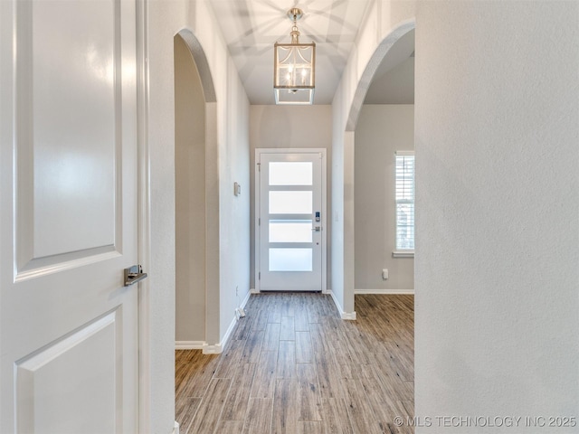 7809 S Redbud Ave, Broken Arrow, OK 74011 - foyer featuring arched walkways, wood finished floors, and a chandelier