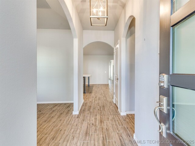 7809 S Redbud Ave, Broken Arrow, OK 74011 - foyer featuring arched walkways, wood finished floors, and a chandelier