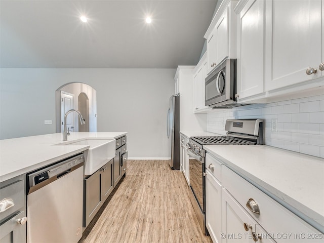 7809 S Redbud Ave, Broken Arrow, OK 74011 - kitchen featuring stainless steel appliances, light countertops, backsplash, white cabinets, and light wood-type flooring