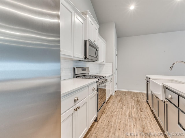 7809 S Redbud Ave, Broken Arrow, OK 74011 - kitchen with appliances with stainless steel finishes, backsplash, white cabinets, light countertops, and light wood-style flooring