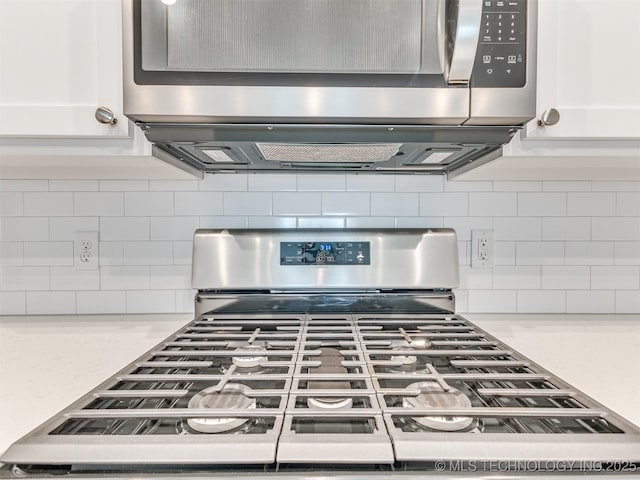 7809 S Redbud Ave, Broken Arrow, OK 74011 - kitchen view of stainless steel appliances, backsplash, and white cabinets