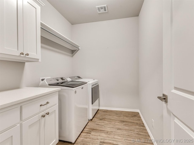 7809 S Redbud Ave, Broken Arrow, OK 74011 - laundry room featuring washer and clothes dryer, cabinet space, and light wood-style flooring