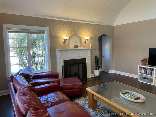 3156 S Madison Ave, Tulsa, OK 74105 - living room with wood finished floors, a textured wall, arched walkways, crown molding, and a fireplace