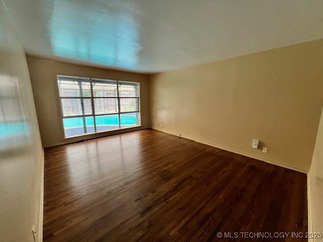 3707 Canton Ave, Tulsa, OK 74135 - unfurnished room featuring dark wood-type flooring and baseboards