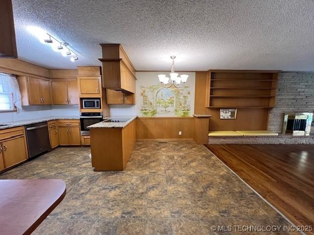 3707 Canton Ave, Tulsa, OK 74135 - kitchen featuring appliances with stainless steel finishes, a chandelier, a textured ceiling, a fireplace, and light countertops