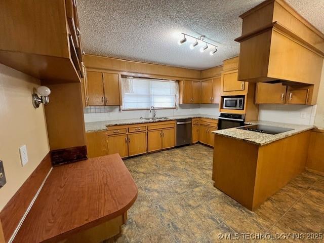 3707 Canton Ave, Tulsa, OK 74135 - kitchen with stainless steel appliances, brown cabinetry, a peninsula, a textured ceiling, and light countertops