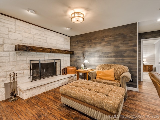 7001 S Redbud Ave, Broken Arrow, OK 74011 - living area with wood walls, a stone fireplace, and wood finished floors