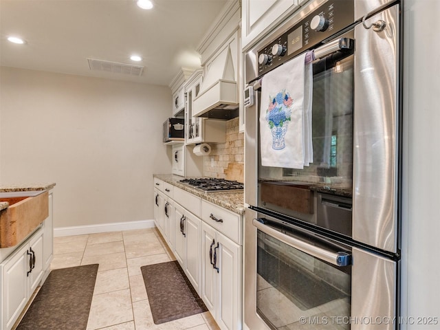 7001 S Redbud Ave, Broken Arrow, OK 74011 - kitchen with tasteful backsplash, stainless steel appliances, light stone counters, white cabinetry, and recessed lighting