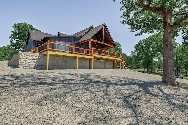 409340 E 1190th Rd, Eufaula, OK 74432 - rear view of property with board and batten siding, driveway, a wooden deck, and a garage
