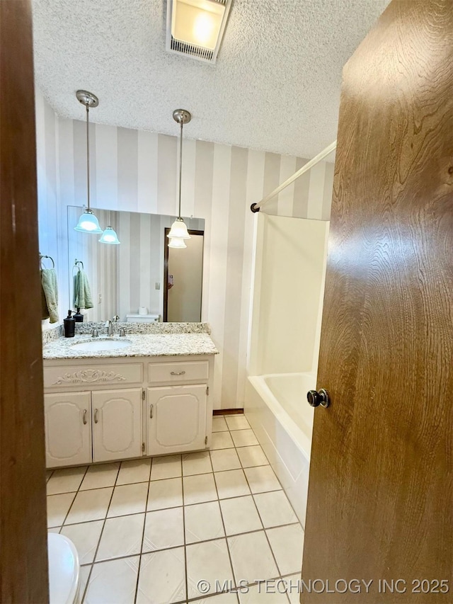 9613 N 107th E Ave, Owasso, OK 74055 - bathroom with wallpapered walls, vanity, bathtub / shower combination, tile patterned flooring, and a textured ceiling