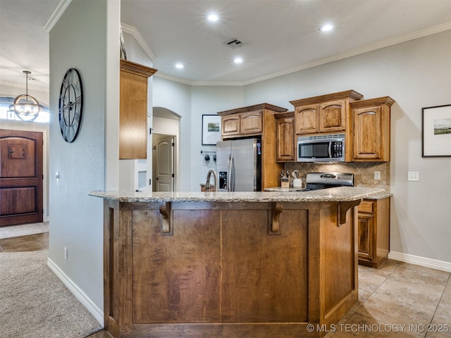 2603 S 16th Pl, Broken Arrow, OK 74012 - kitchen with stainless steel appliances, a breakfast bar area, light stone counters, decorative backsplash, and brown cabinets