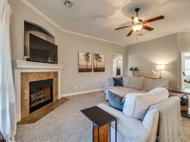 2603 S 16th Pl, Broken Arrow, OK 74012 - living room with carpet, a ceiling fan, arched walkways, a tile fireplace, and crown molding