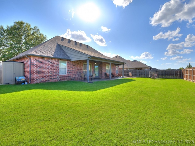 2603 S 16th Pl, Broken Arrow, OK 74012 - back of house featuring a fenced backyard, brick siding, a patio, a storage shed, and roof with shingles