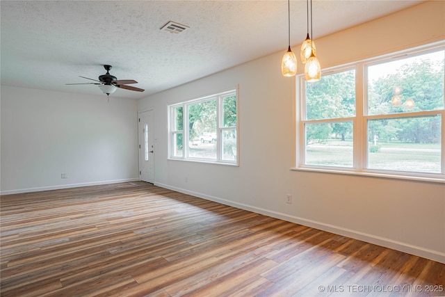 11598 E Oak St, Claremore, OK 74019 - empty room with wood finished floors, ceiling fan, and a textured ceiling